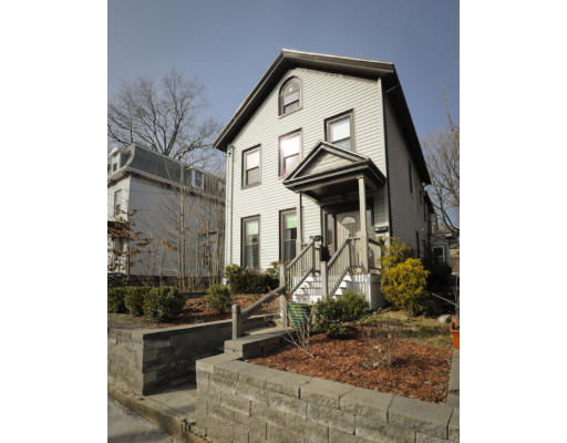 Front view of a two-story house with a gable roof and steps leading to the entrance.
