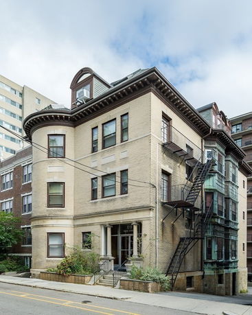 Front view of a multi-story building with a fire escape.