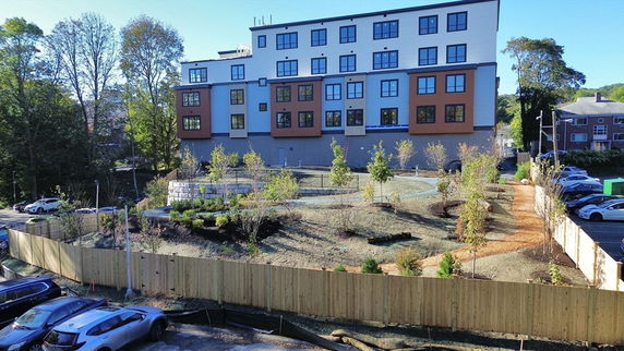 Front view of a multi-story building with numerous windows and a landscaped area.