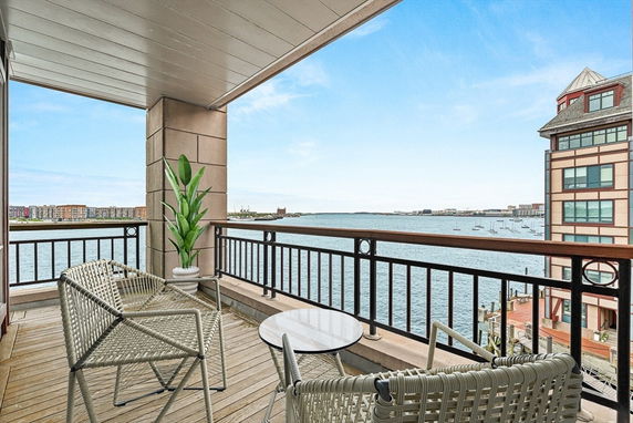 Balcony view overlooking a body of water with buildings in the distance.