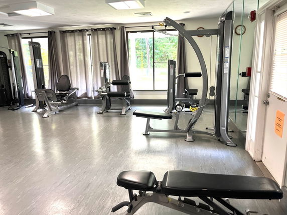 Indoor gym area with exercise machines and benches.