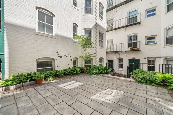 Courtyard view of a brick building with multiple windows and small balconies.