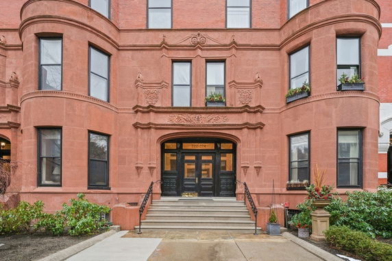 Front view of a historic multi-story building with ornate architectural details and curved windows.