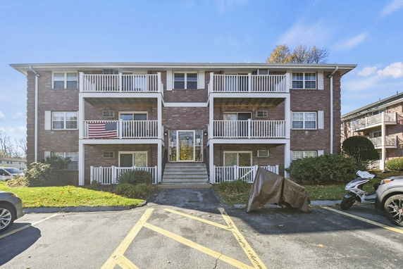 Front view of a three-story apartment building with balconies.