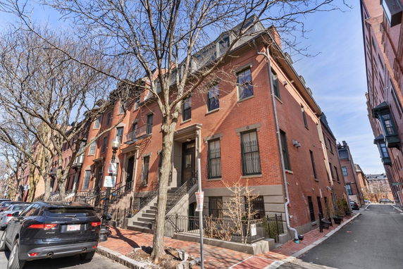 Front view of a row of brick townhouses with multiple stories.