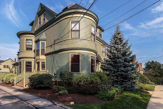 Front view of a multi-story house with rounded bay windows.