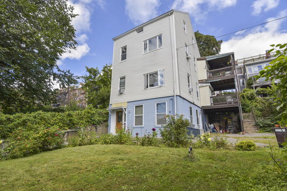 Front view of a multi-story building with a yard.