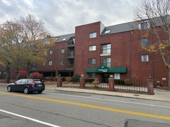 Front view of a multi-story brick building with a green canopy entrance.