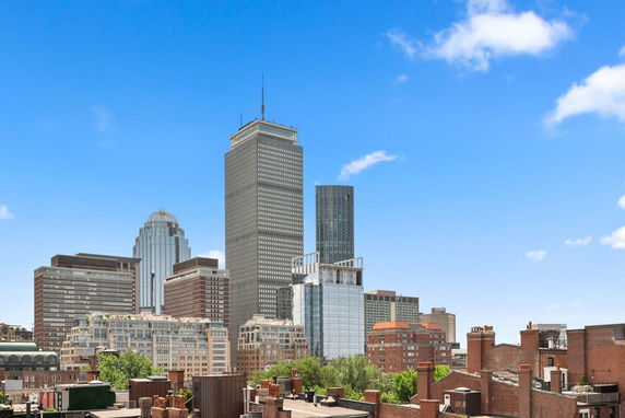 Panoramic view of a city skyline with tall buildings and a clear blue sky.