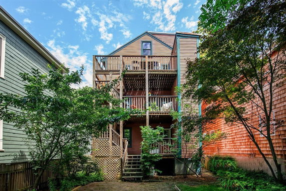 Rear view of a multi-story house with wooden balconies.