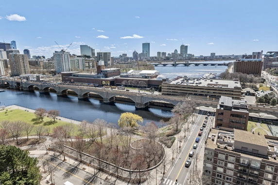 Panoramic view of a city with a river, bridges, and various buildings.