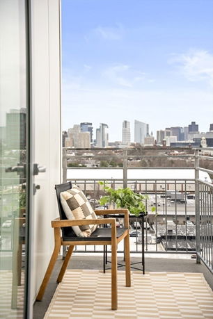 Balcony with a chair and a view of the city skyline.