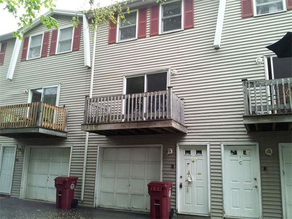 Front view of a multi-story residential building with garages and balconies.