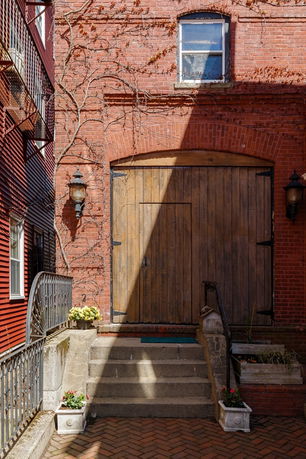 Front view of a building with a large wooden door and brick facade.
