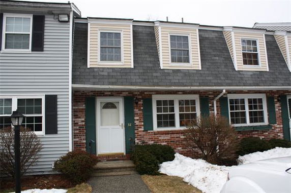 Front view of a two-story townhouse with brick and siding exterior.