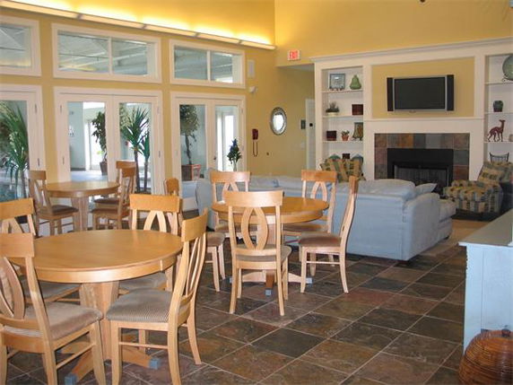 Interior view of a clubhouse with seating area and fireplace.
