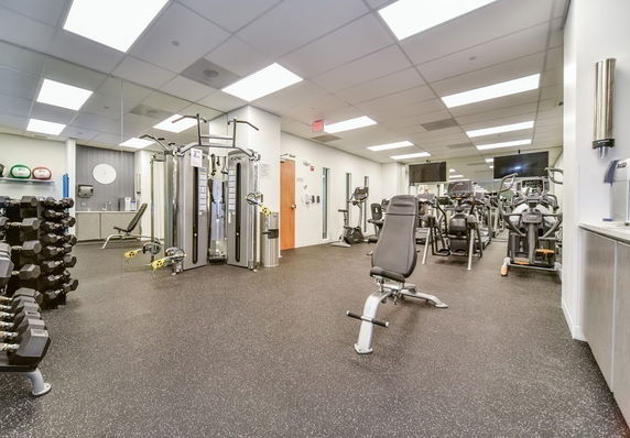 Interior view of a gym with exercise equipment and weights.
