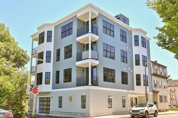 Front view of a multi-story residential building with balconies.