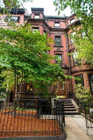 Front view of a multi-story brick building with steps leading to the entrance.