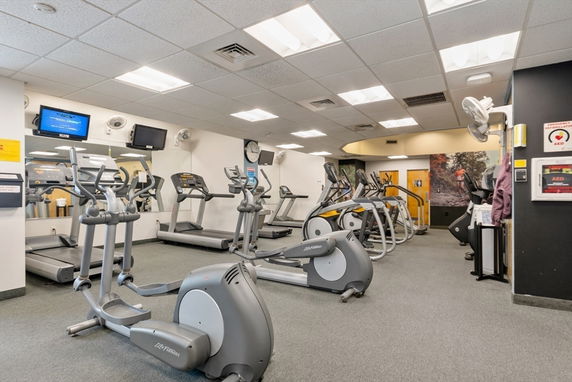 Indoor gym area with treadmills and elliptical machines.