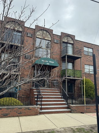 Front view of a brick apartment building with balconies and staircase.