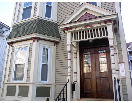 Detailed view of a house entrance with a wooden door and decorative architectural features.