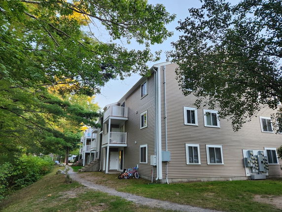 Side view of a multi-story residential building with balconies.