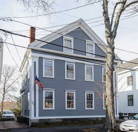 Front view of a two-story house with gray siding and a gable roof.