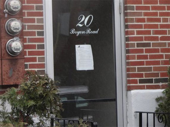 Front view of a building entrance with a glass door displaying the address '20 Bryon Road'.