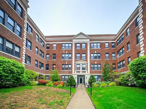Front view of a multi-story brick building with a central entrance.