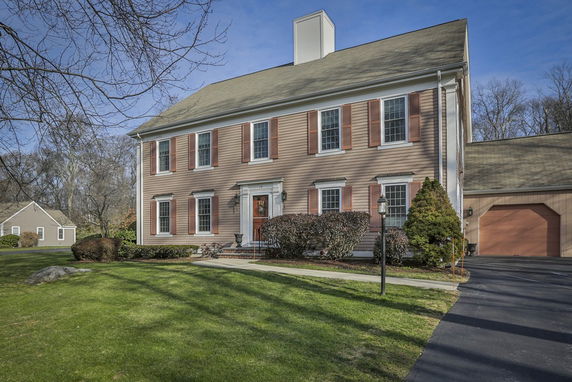 Front view of a two-story house with a chimney and an attached garage.