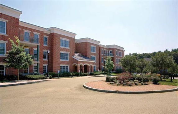 Front view of a three-story brick building with multiple windows.