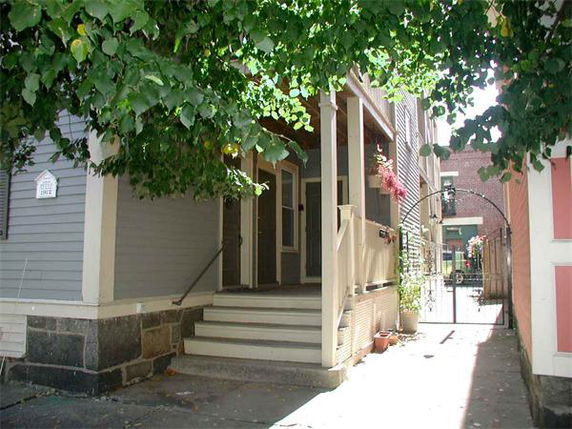 Front view of a house with a small porch and steps leading up to the entrance.