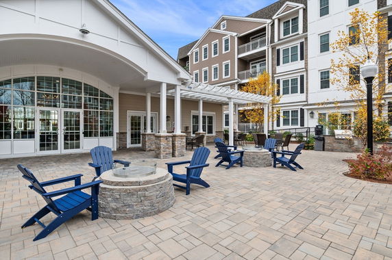 Front view of a multi-story building with outdoor seating and a covered entrance.