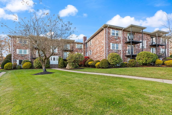 Front view of a two-story brick apartment building with balconies.