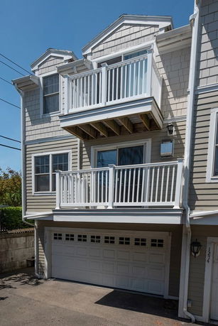 Front view of a multi-story house with a garage and balconies.