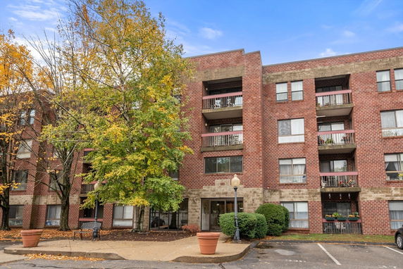 Front view of a brick apartment building with multiple balconies.