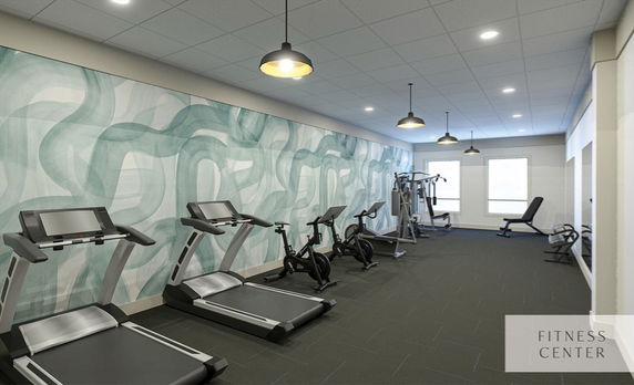 Indoor gym area with treadmills, exercise bikes, and weight machines.