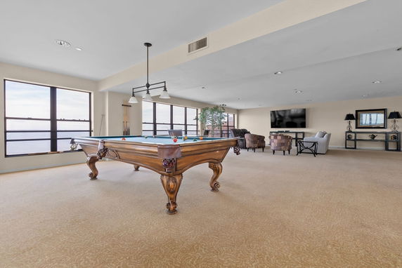 Interior view of a room with a pool table and seating area.