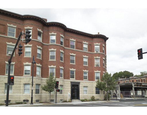 Front view of a multi-story brick building with distinctive architectural details and a prominent street corner location.