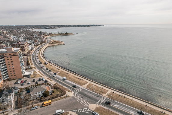 Panoramic view of a coastal road and surrounding residential area.