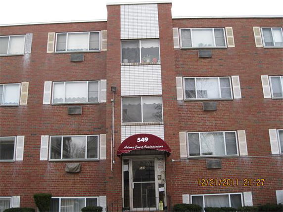 Front view of a multi-story brick building with multiple windows.