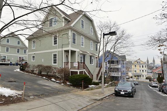 Front view of a multi-story house with a sloped roof.