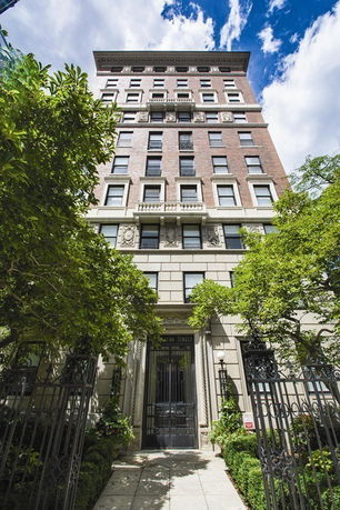 Front view of a multi-story building with a decorative facade and gated entrance.