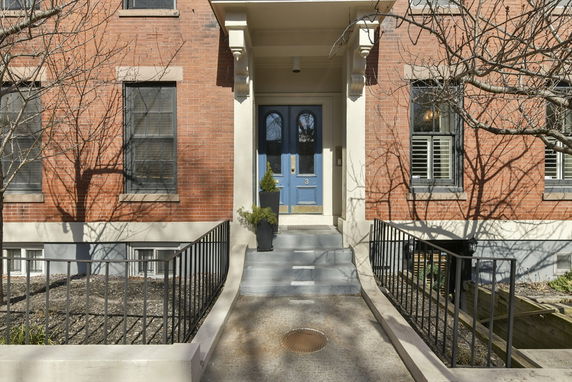 Front view of a brick building with blue door and black window frames.