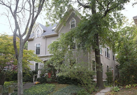 Front view of a two-story house with gabled roof and dormer windows.