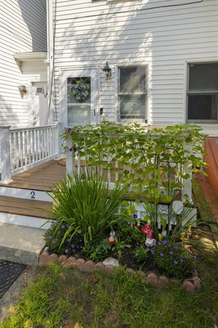 Front view of a house with a small porch and a garden.