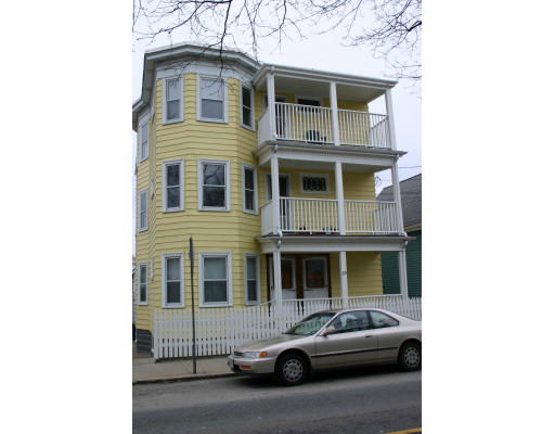 Front view of a multi-story yellow building with balconies.