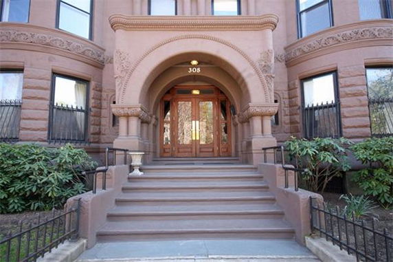 Front view of a multi-story building with a decorated stone arch entrance.