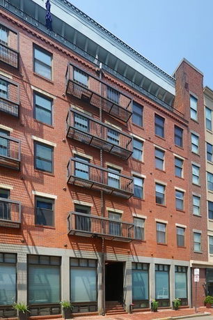 Front view of a multi-story brick building with balconies.